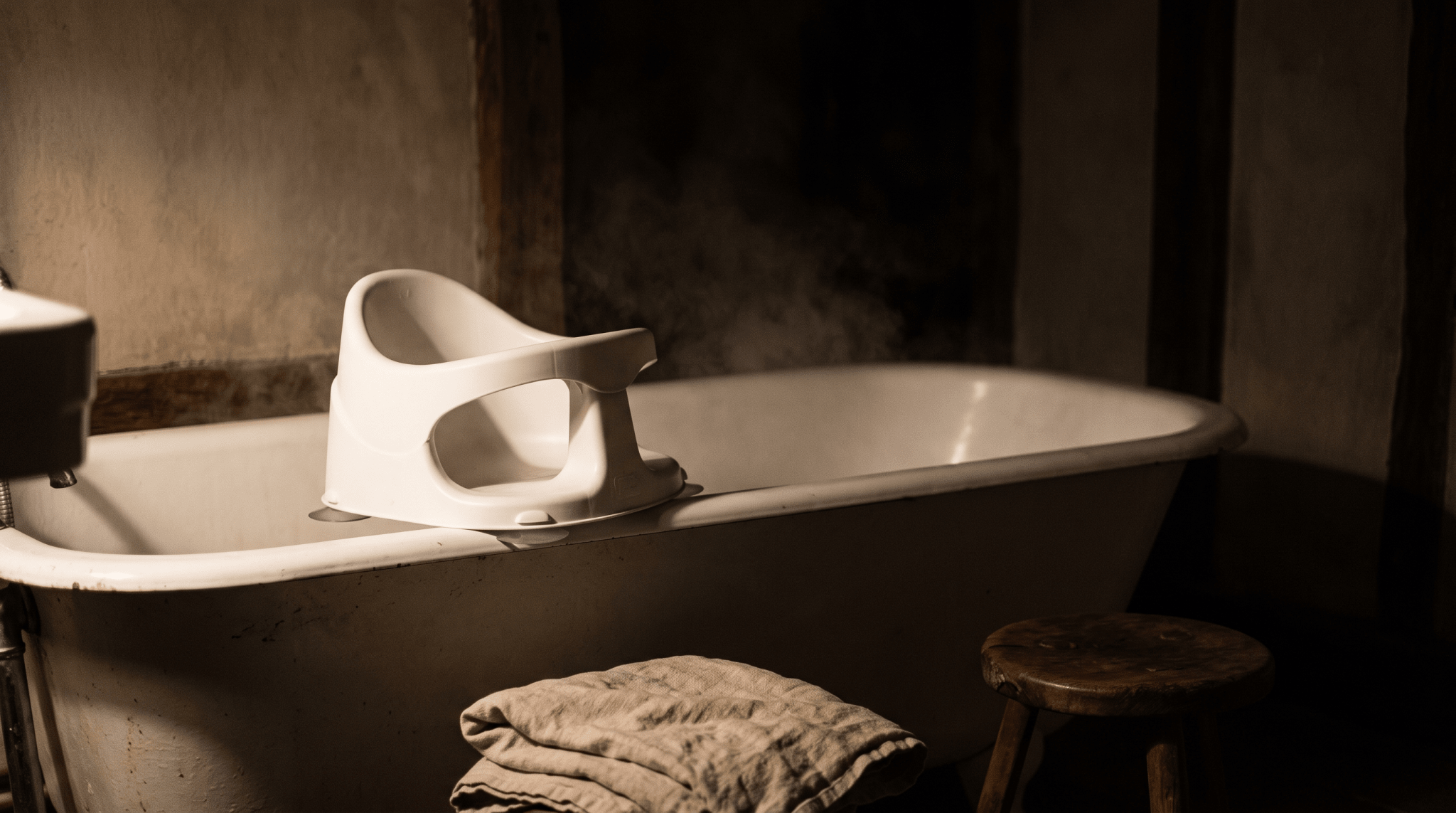 Siège de bain bébé posé dans une baignoire, lumière chaude du soir — Treelys®